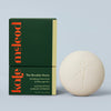 Kate McLeod Breathe Stone lotion bar and packaging on a light blue background