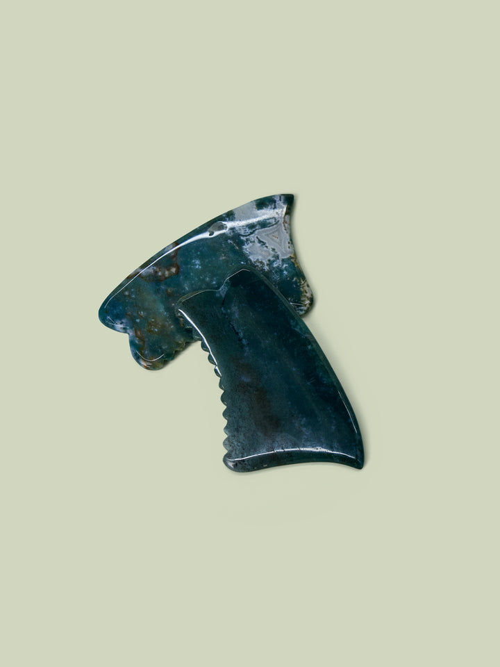 Two Face Gua Shas overlaid on a light green background.