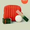 Poppy-colored travel bag, body stone, The Foot Stone box, and the foot file on a light green background with 'New In' label.