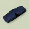 Lunya Silk Sleep mask resting against light green background.