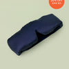 Lunya Silk Sleep mask resting against light green background.