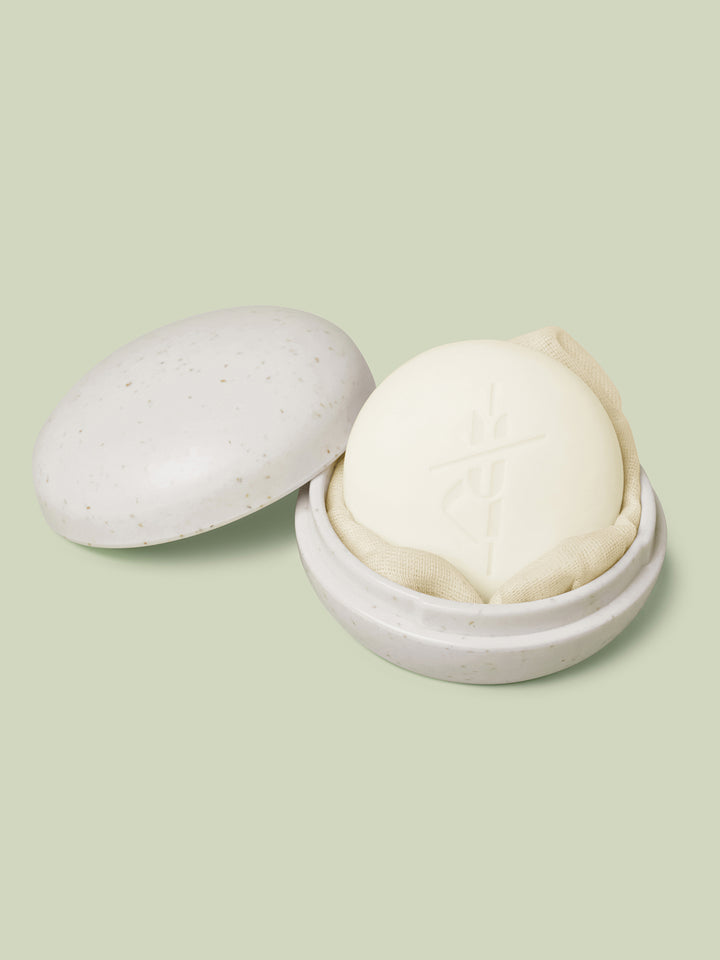 Full-Size Travel Case in ivory color laying open with a full-size Body Stone nestled inside on a light green background.