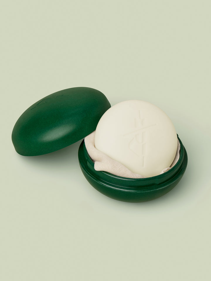 Full-Size Travel Case in Pine Green color and full-size Body Stone nestled inside against light green background.