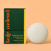 Kale McLeod Recovery Stone lotion bar and packaging on a peach background