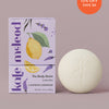 Lavender Lemonade body stone lotion bar with citrus packaging on a light lavender background.