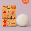 Kate McLeod Tangerine & Vanilla lotion bar with packaging on a light purple background