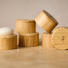 Stack of bamboo containers on a wooden surface with a neutral background