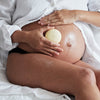 Pregnant woman holding the Mama Stone against their belly