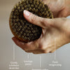 Hand holding the dry brush with text describing its benefits on a neutral background.