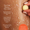 Person applying a lathered Pebble to their skin with text on how to use it. Turn your shower into a spa.