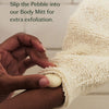 Person using a bamboo Body Mitt with a Pebble for exfoliation, text overlay 'Better Together'. Slip the Pebble into our Body Mitt for extra exfoliation.