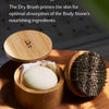 Bamboo canister sits atop a wooden table holding the body stone and the dry brush is propped up next to it. Text over the image shares why the two products are the perfect pairing.