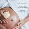 Person using a Mama Stone on their pregnant belly with text instructions.