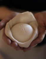 Kate McLeod holding a handcrafted Body Stone solid moisturizer at our Hudson Valley workshop