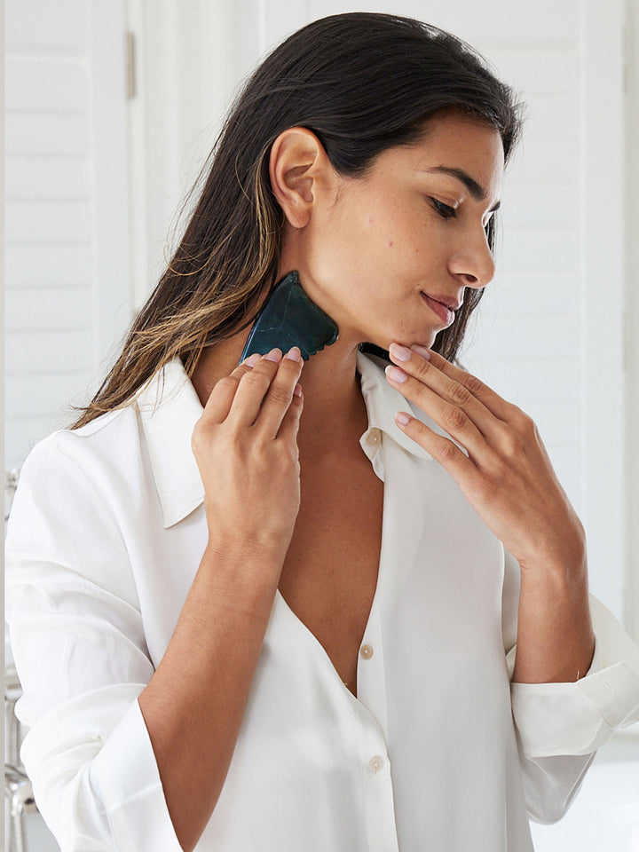 A model using the Face Gua Sha on her neck and jaw.