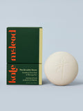 Kate McLeod Breathe Stone lotion bar and packaging on a light blue background