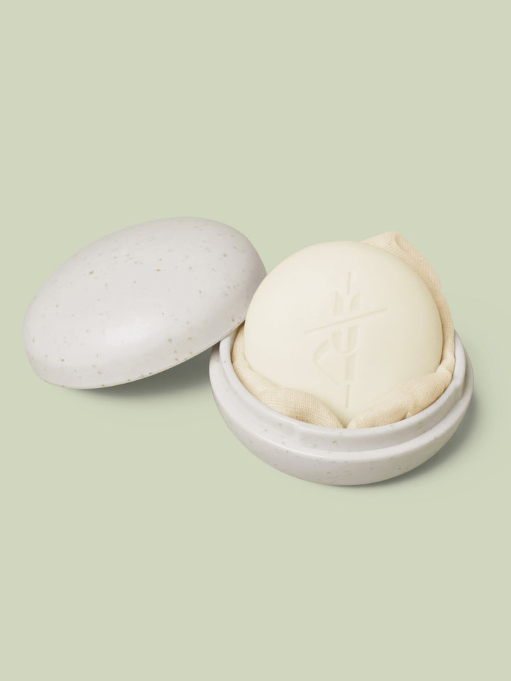 Full-Size Travel Case in ivory color laying open with a full-size Body Stone nestled inside on a light green background.