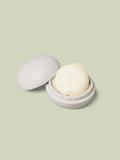 Mini Travel Case in ivory color laying open with a mini Body Stone nestled inside on a light green background.