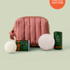 Mini travel bag in limited-edition blush that includes the sleep stone mini and everywhere stick shown on a light green background. 