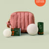Mini travel bag in limited-edition blush that includes the sleep stone mini and everywhere stick shown on a light green background. 