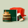 The Spa Gift set features a dry brush, daily pebble, body mitt and poppy-colored travel bag. The set is displayed on a light green background.