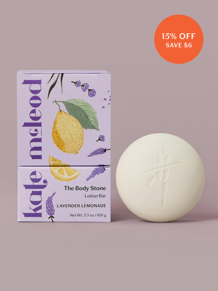 Lavender Lemonade body stone lotion bar with citrus packaging on a light lavender background.