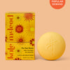 Yellow after sun balm bar and packaging on a peach background