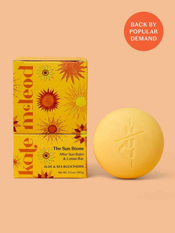 Yellow after sun balm bar and packaging on a peach background