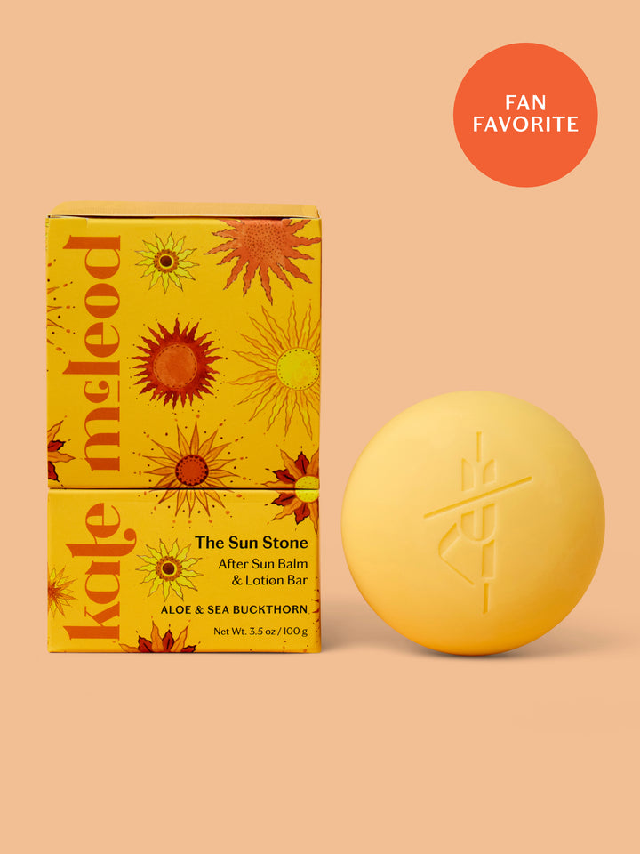 Yellow after sun balm bar and packaging on a peach background