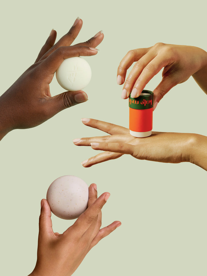 Three hands applying and holding the sleep stone mini, everywhere stick and travel case on a light green background. 