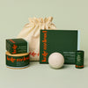 Display of what can fit inside the large gift bag. A Body Stone Refill, a Body Stone Starter Kit, Pebble box, Mini Travel Case, and Everywhere Stick.