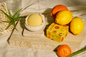 Sun Stone in a Travel Case with lemons, oranges, and limited edition packaging on a stone and linen background.