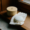 Bamboo container styled beside the best-selling Kate McLeod body stone sitting atop a window seal. 