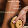 Person using the dry brush on their leg with text about design and materials.