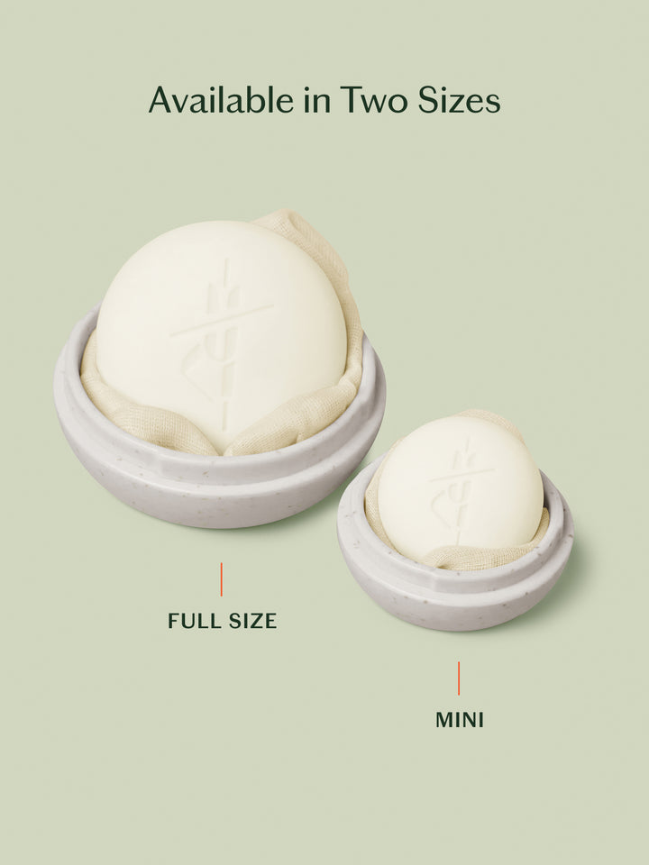 Oatmeal Full-Size Travel Case with full-size Body Stone inside and ivory Mini Travel Case with mini Body Stone inside, sitting side-by-side.