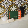 The body mitt folded neatly on the tiled bathroom counter paired alongside Kate McLeod's Breathe Pebble and Travel Case.
