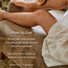 Woman sitting on a brown sofa exfoliating her skin with the dry brush and how to use text over the image.