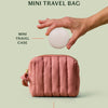 The limited-edition blush travel bag alongside a the mini travel case for a size comparison on a light green background.