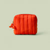Poppy quilted mini travel bag on a light green background.