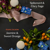 Spring limited edition Body Stones with packaging, ingredients, and ribbons laid against a dark background.