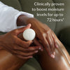 A person applying a white circular cosmetic product to their leg while sitting on a green couch. White text on the image reads: 'Clinically proven to boost moisture levels for up to 72 hours'.