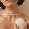 Woman holding a lotion bar with text about intensely moisturizing lotion bar
