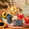 Tray with snacks, drinks, and Bug Balm insect repellent Moisture Stick and Body Stone on an outdoor wooden table with 'Perfect for Travel' text. TSA-friendly and carry-on approved.