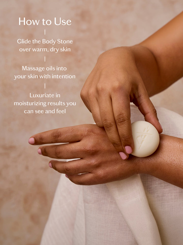 A person's hands apply a white oval body stone with a geometric star design onto their wrist, demonstrating its use. The image includes a 'How to Use' text overlay on the left, set against a warm beige background with a white textured towel.