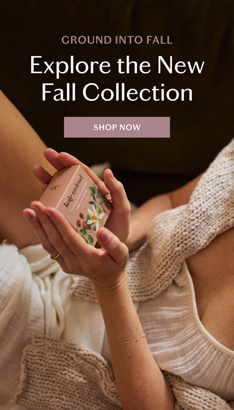 A person in a cozy knit sweater holds a small pink box labeled 'Ground Into Fall' and 'Autumn Harvest' while promotional text at the top reads 'Explore the New Fall Collection' with a 'SHOP NOW' button.