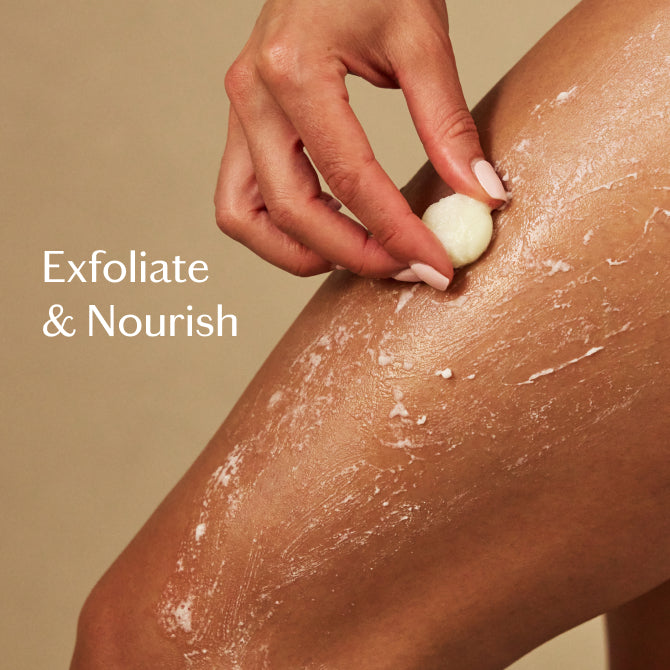 A close-up of a person's leg with white exfoliating scrub being rubbed by a hand, with the text 'Exfoliate & Nourish' on the left against a warm beige background.