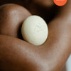 Image of Kate McLeod Body Stone solid moisturizer against nourished, glowing skin.